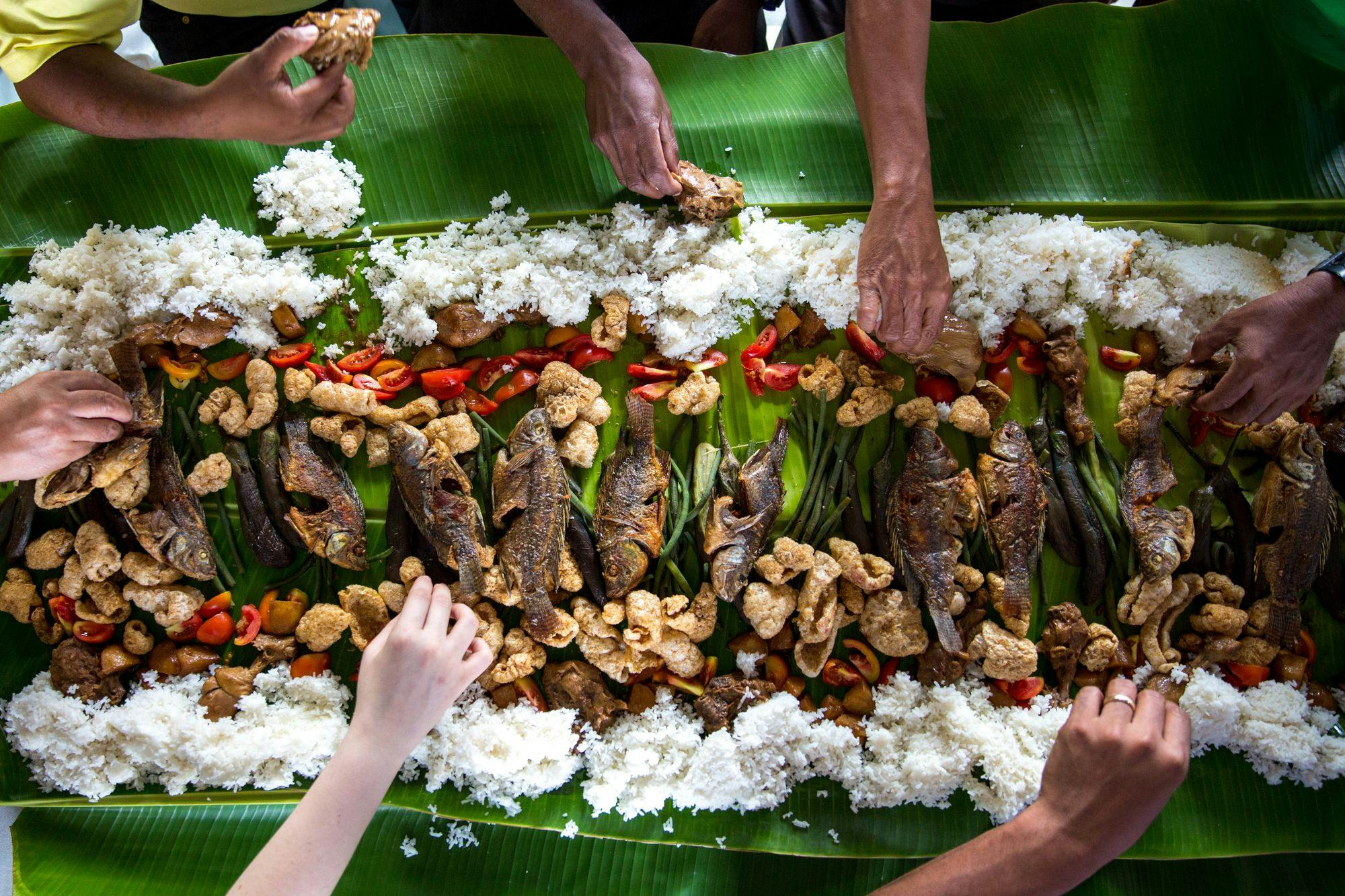 filipino-food-platter-hands-grabbing-food