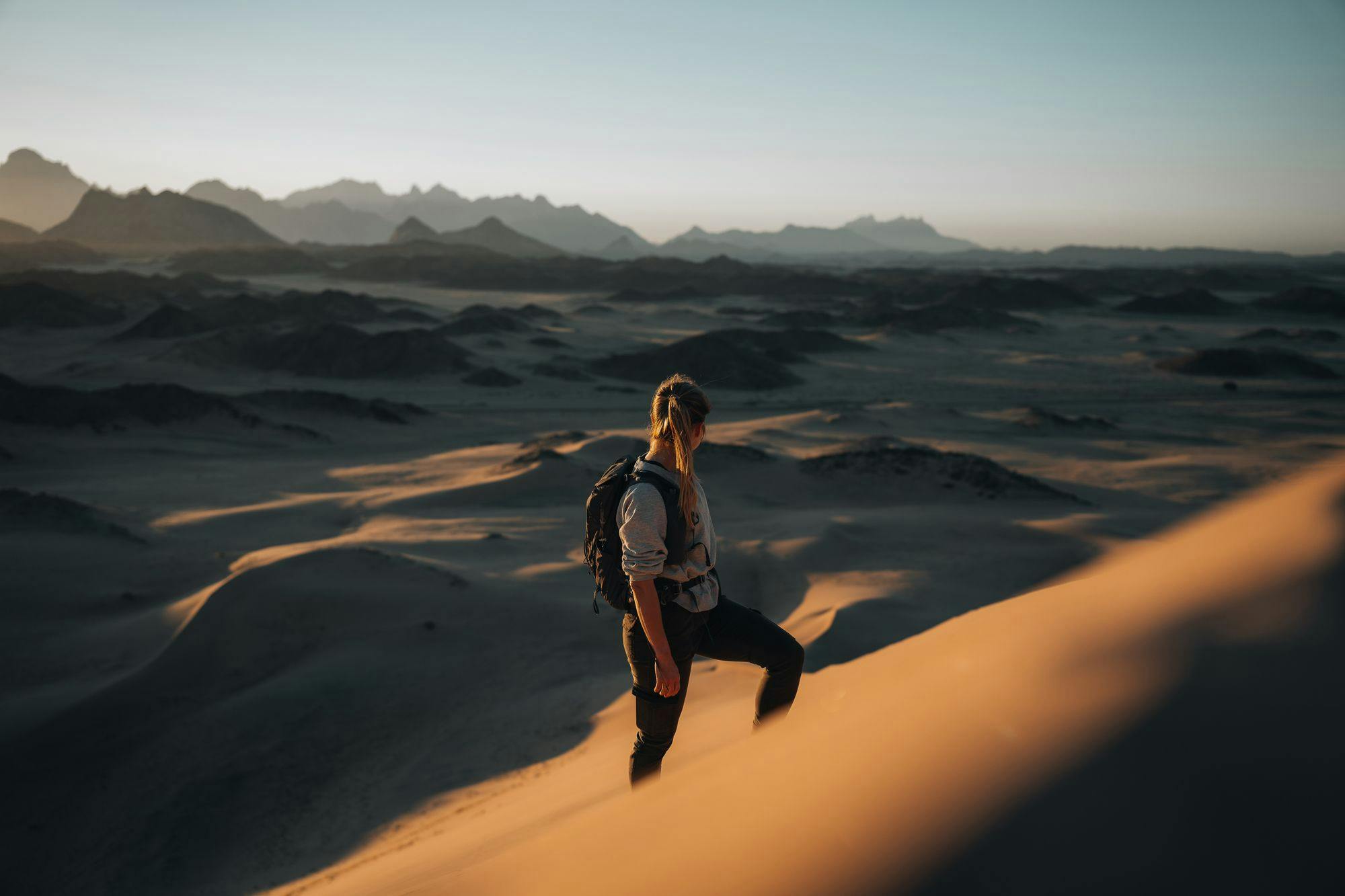 woman-looking-at-desert-with-backpack